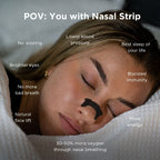 A woman sleeping peacefully with a black nasal strip applied to her nose, surrounded by white bedding.